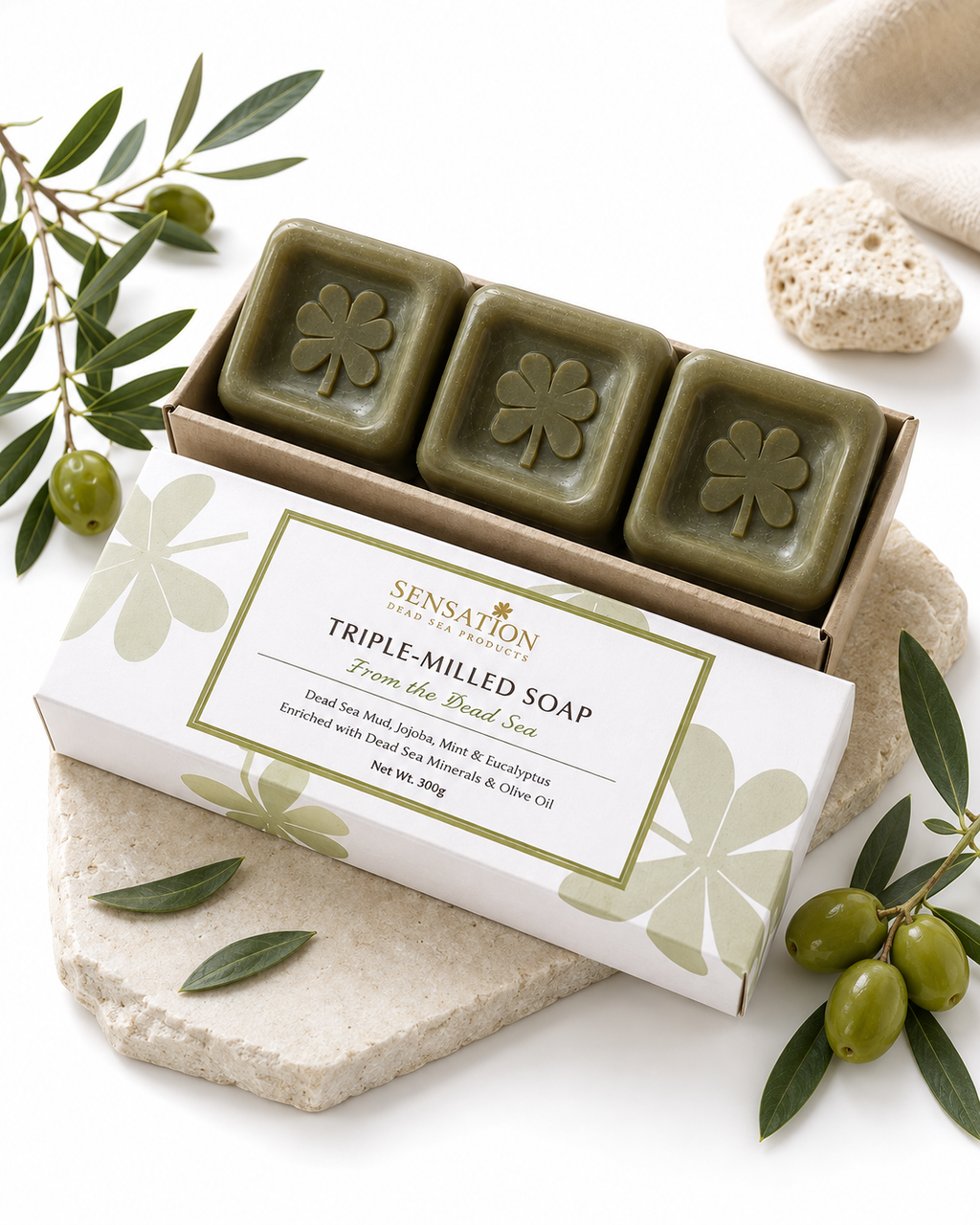Triple-Milled Dead Sea Mud Soaps in a decorative box with olive leaves and stones.